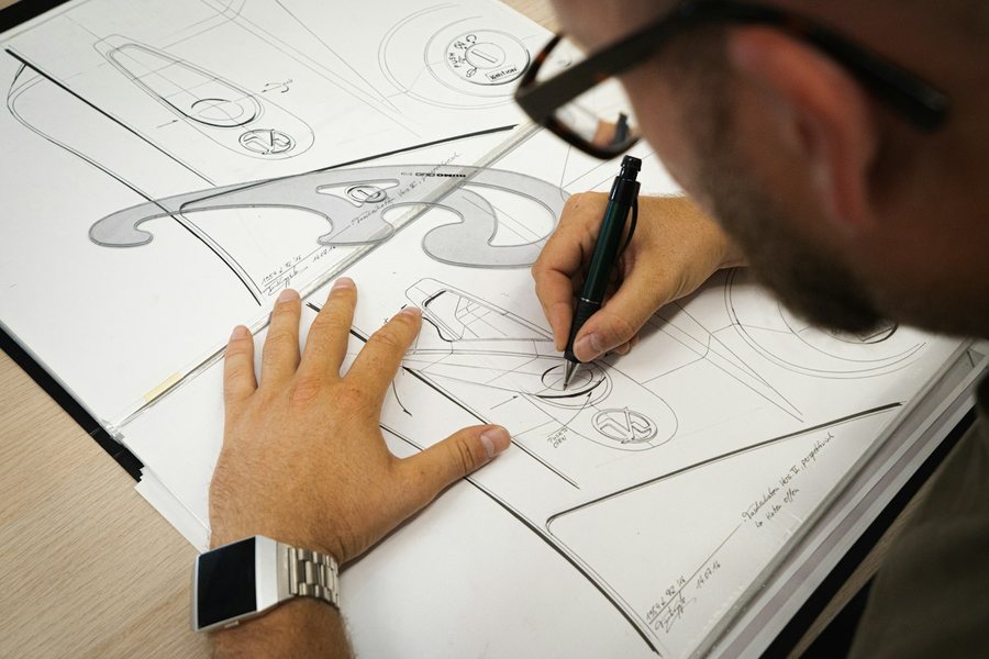 紙にデザインのスケッチを描く手元